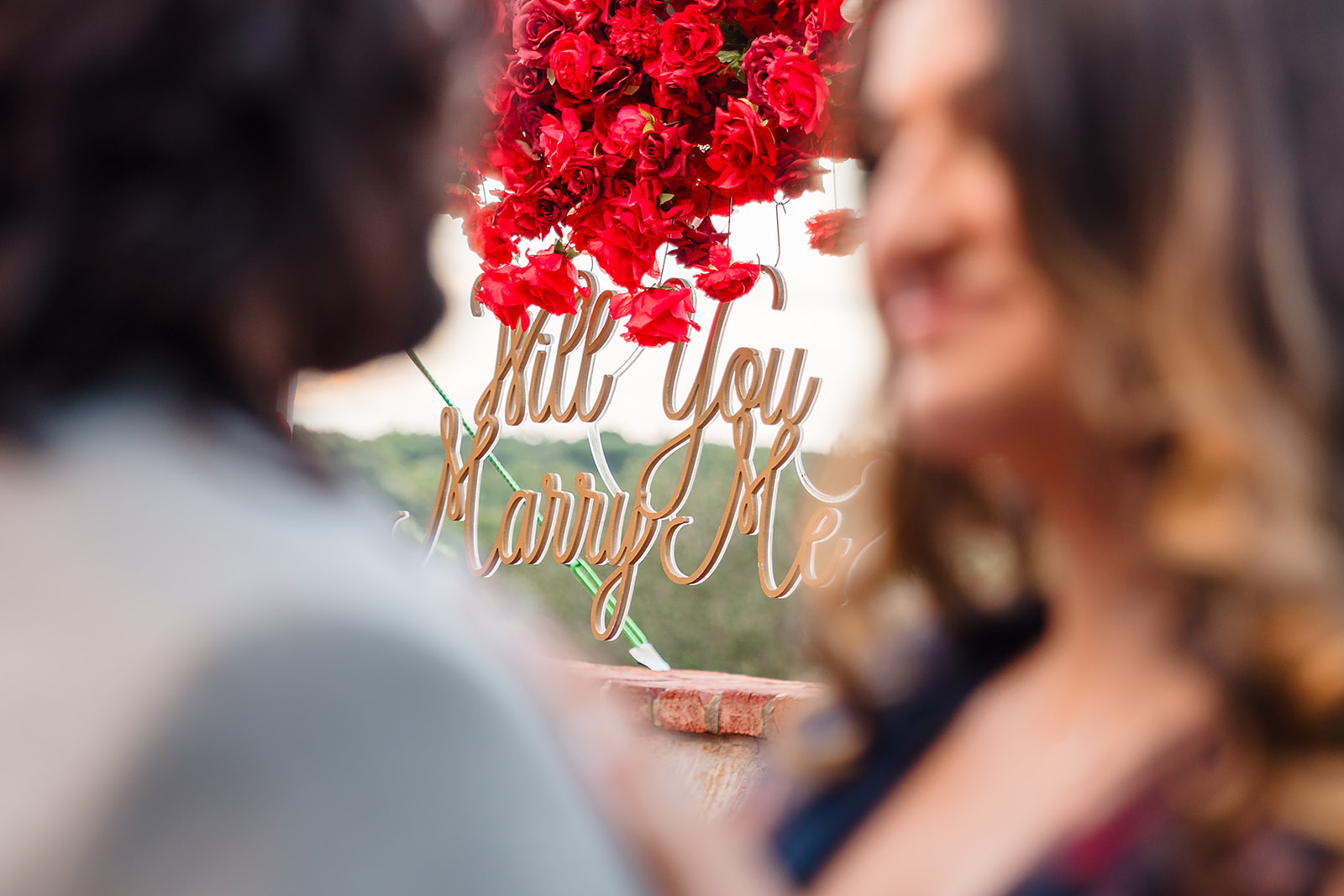 Breathtaking proposal moment: Wide shot of the same couple, capturing him as he opens the ring box against the romantic backdrop of The Oak Terrace Wedding Venue at the Hyatt Regency Grand Cypress in Orlando FL.