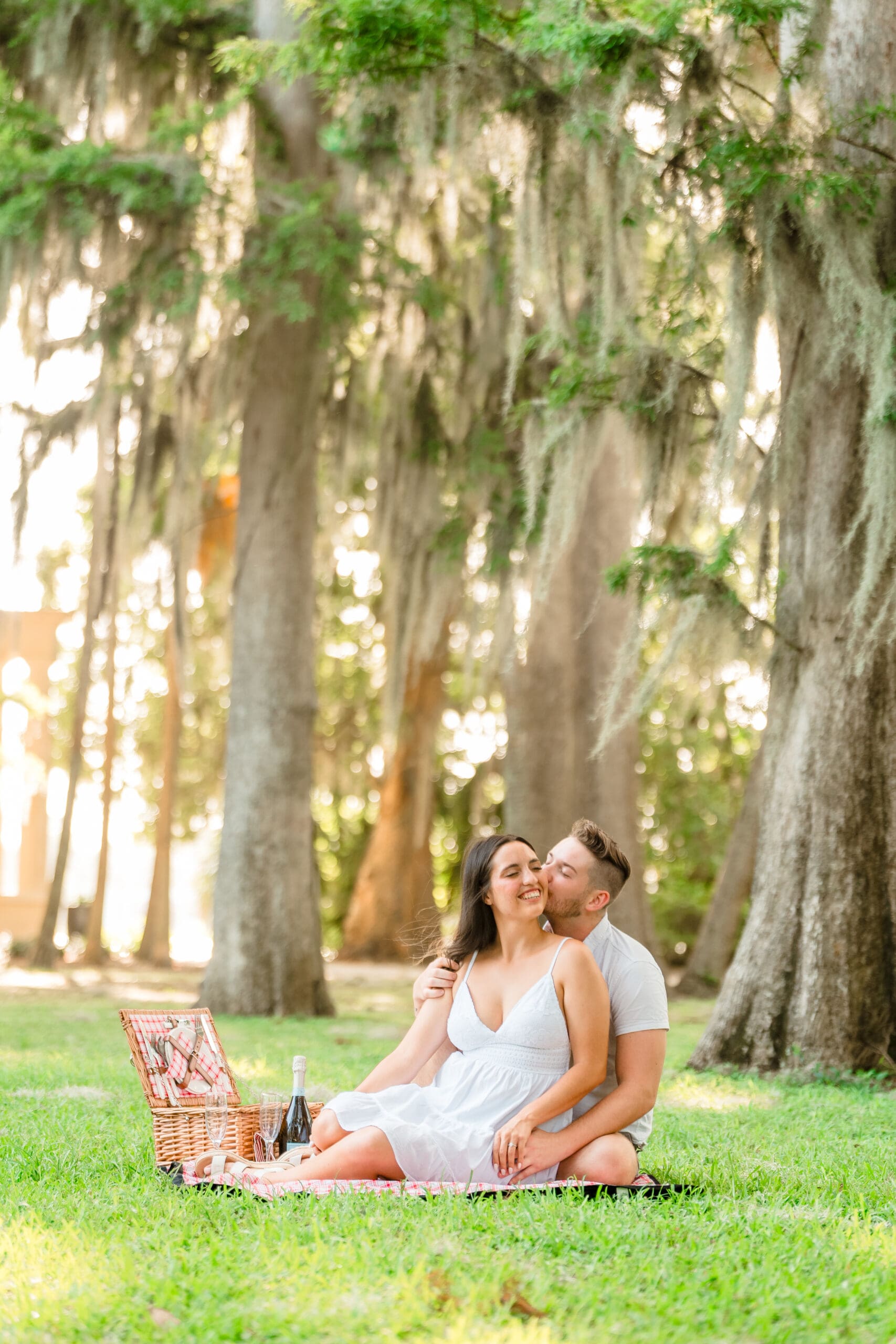 An engagement photo of a couple kissing passionately under a beautiful archway.