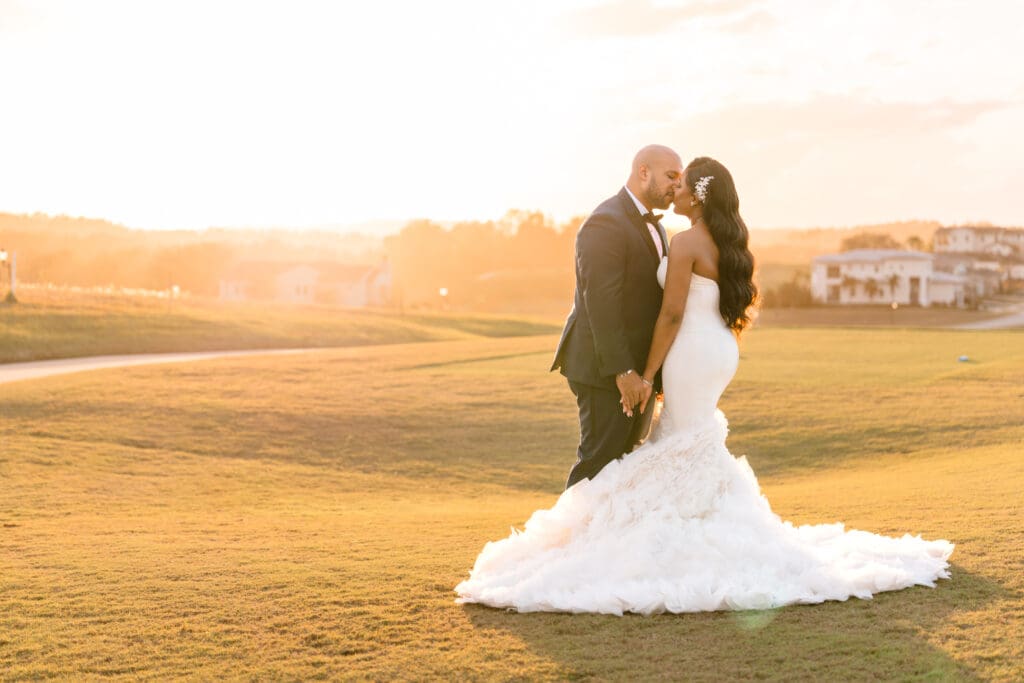 Bride and groom at Bella Collina wedding venue in Orlando, Florida, posing during golden hour on the grand lawn.