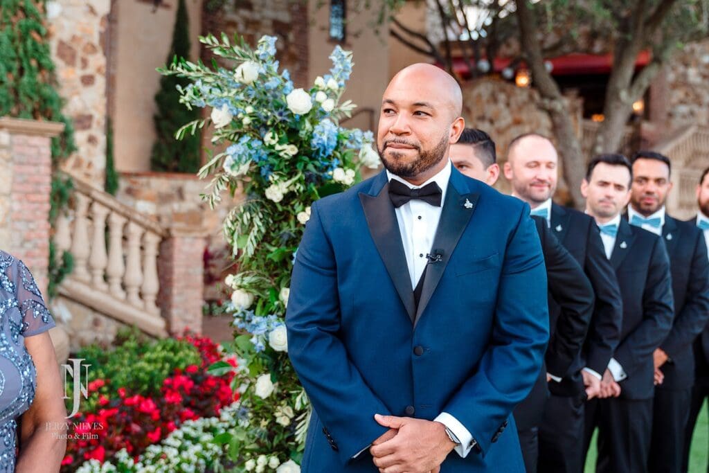 groom smiling at bride walking down aisle at Bella collina