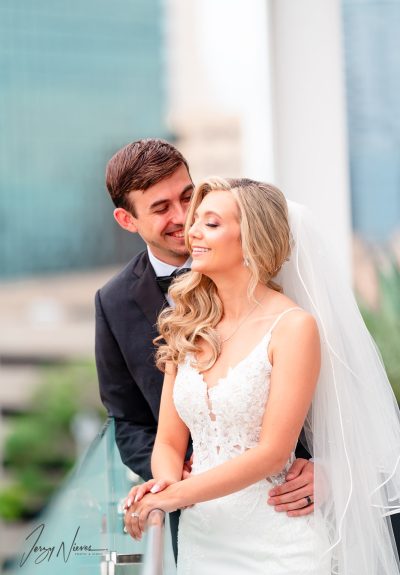 Close-up of newlyweds Brittany and Nathan embracing on the balcony of the Dr. Phillips Center for Performing Arts, focusing on their smiles and joy.