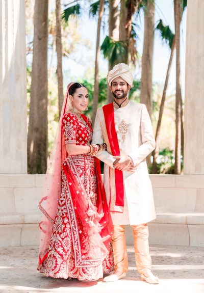 Sabrina and Rahul in traditional Indian wedding attire, standing amidst the scenic beauty of Kraft Azalea Gardens, captured in a long shot by Jerzy.