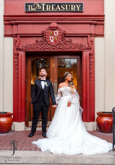 bride and groom portraits in front of red door at The Treasury on the Plaza